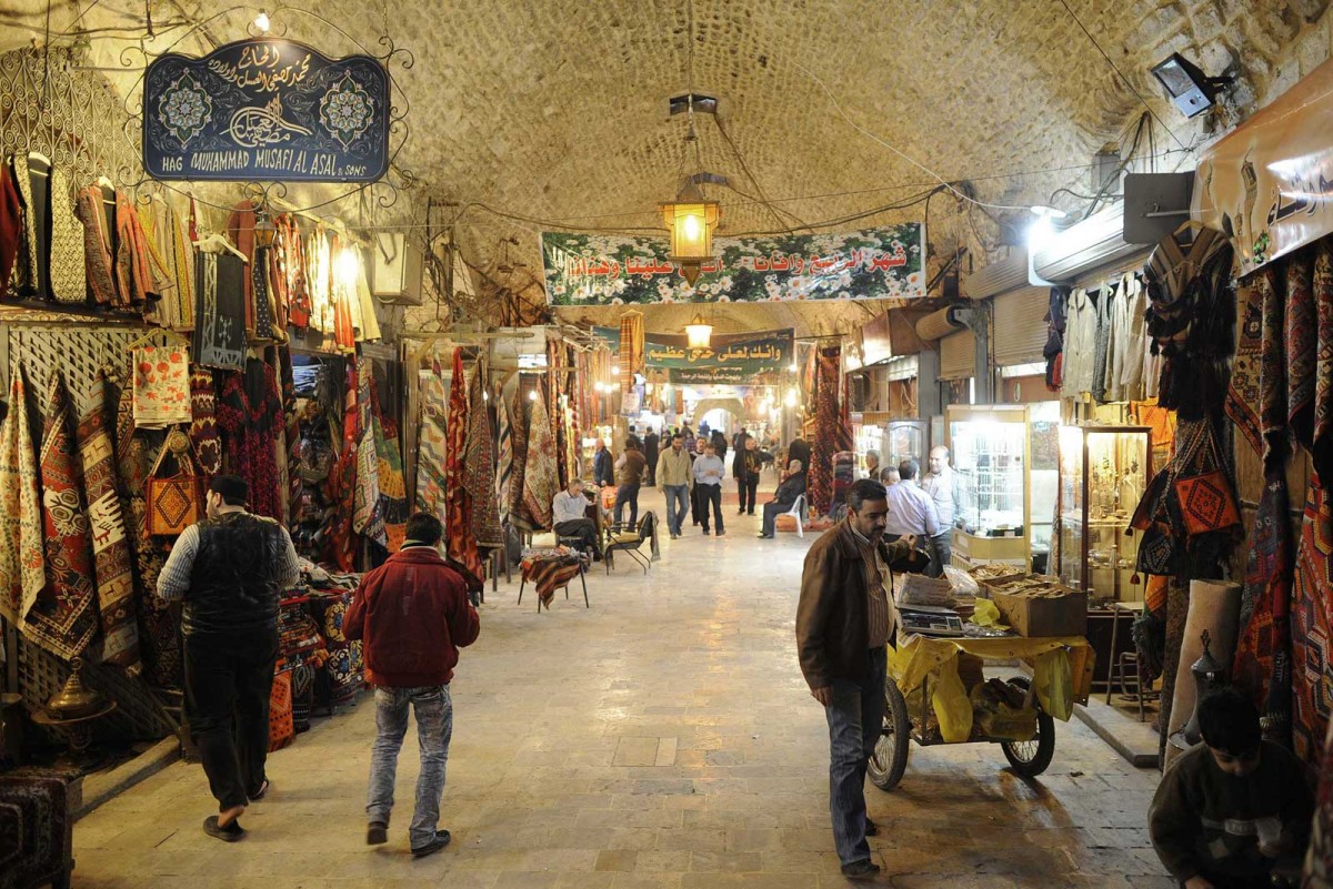 People walk through the Al-Madina Souk market in Aleppo.