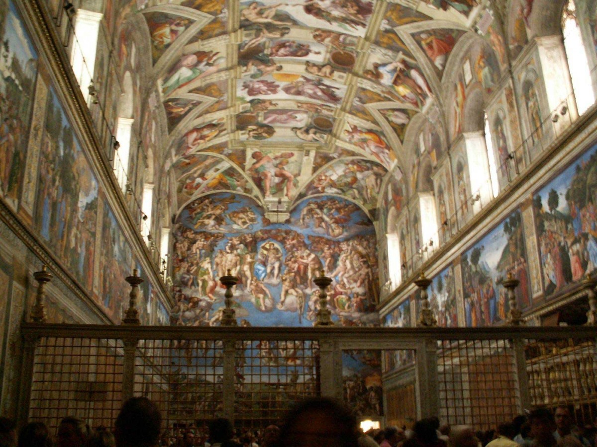 The Sistine Chapel packed with tourists. On the far wall 