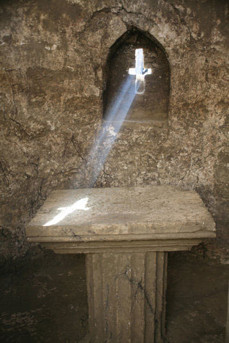 Cross-shaped window in the chapel that, when sunlit, beams its shape onto an altar table. 