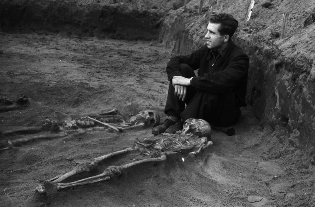 Man guarding recently uncovered human skeletons. © Europeana. Rights reserved.