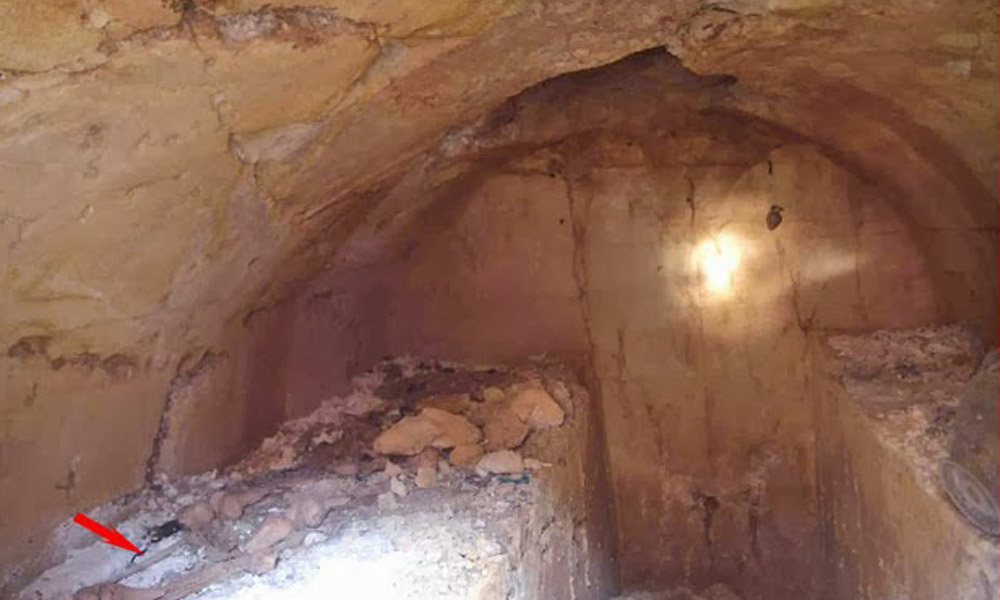 The inside of the newly found Etruscan tomb. The red arrow indicates the mystery skeleton.
