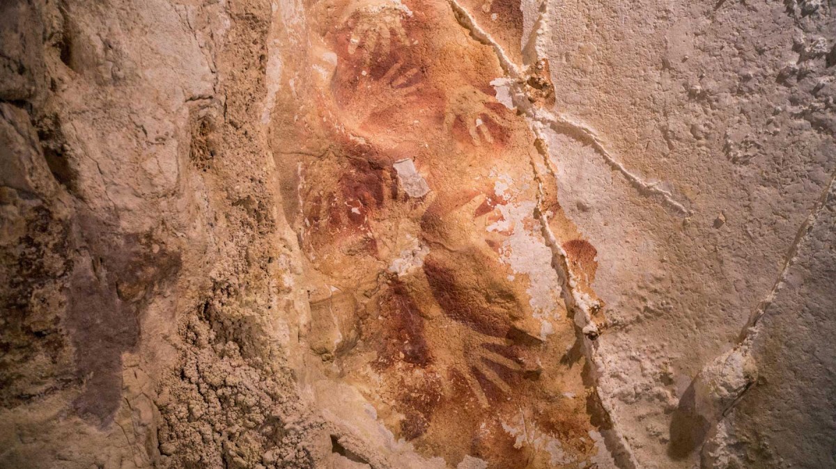 Australian and Indonesian scientists have dated layers of stalactite-like growths that have formed over coloured outlines of human hands.