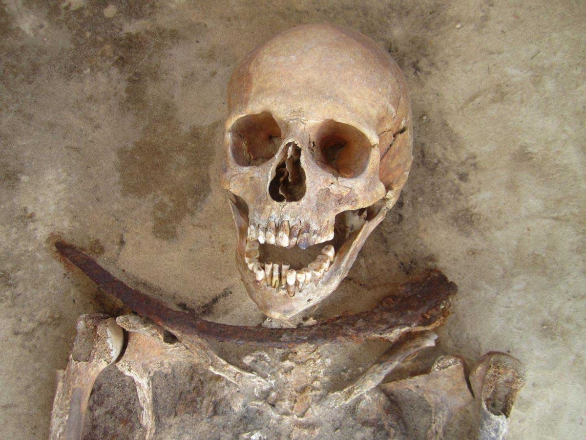Individual 49/2012 (30-39 year old female) is shown with a sickle placed across the neck. Credit: Amy Scott