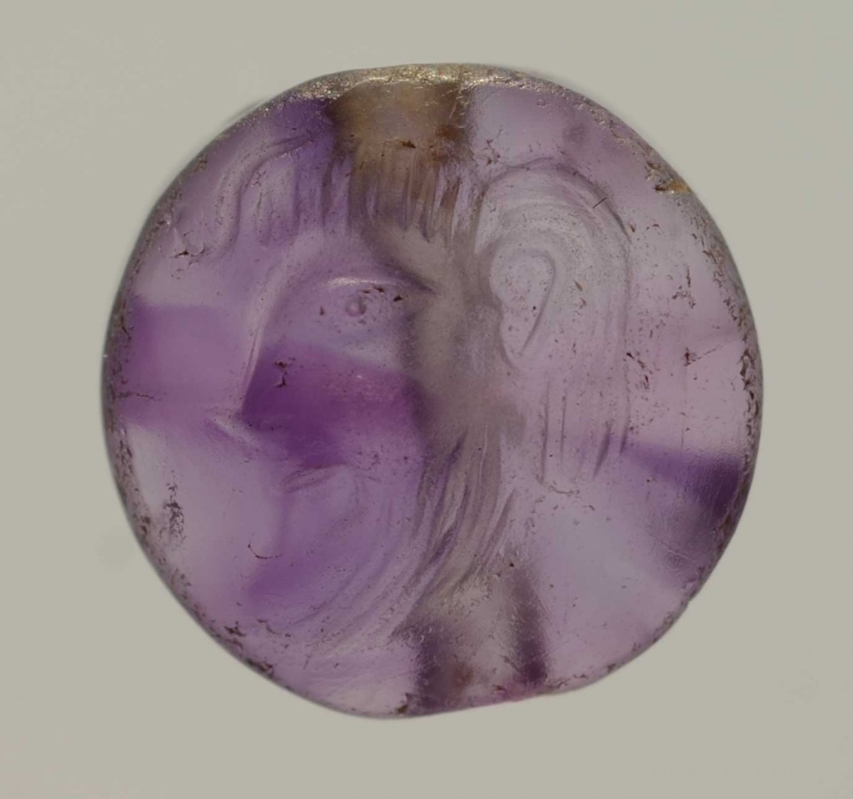 Seal stone made of amethyst depicting a male figure, from Grave C  of the Grave Circle B of Mycenae. 17th-16th c. BC. Mycenaean Antiquities exhibition, Room 4, display case M16, NAM 8708). (Credit: National Archaeological Museum/Eleftherios A. Galanopoulos)