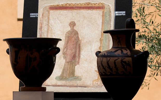 A first century B.C. frescoe, one of 25 artifacts that have been returned, between two vases. Photo Credit: The Telegraph.