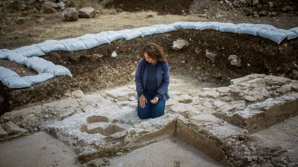Annette Nagar of the Antiquities Authority looks at the baptismal font of the Byzantine-era church discovered at Abu Ghosh. Photo Credit: Times of Israel /Yonatan Sindel / Flash90.