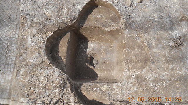 A baptismal font shaped like a four-leaf-clover, symbolizing the cross, found in the excavation.  Photo Credit: Times of Israel /Yonatan Sindel / Flash90.
