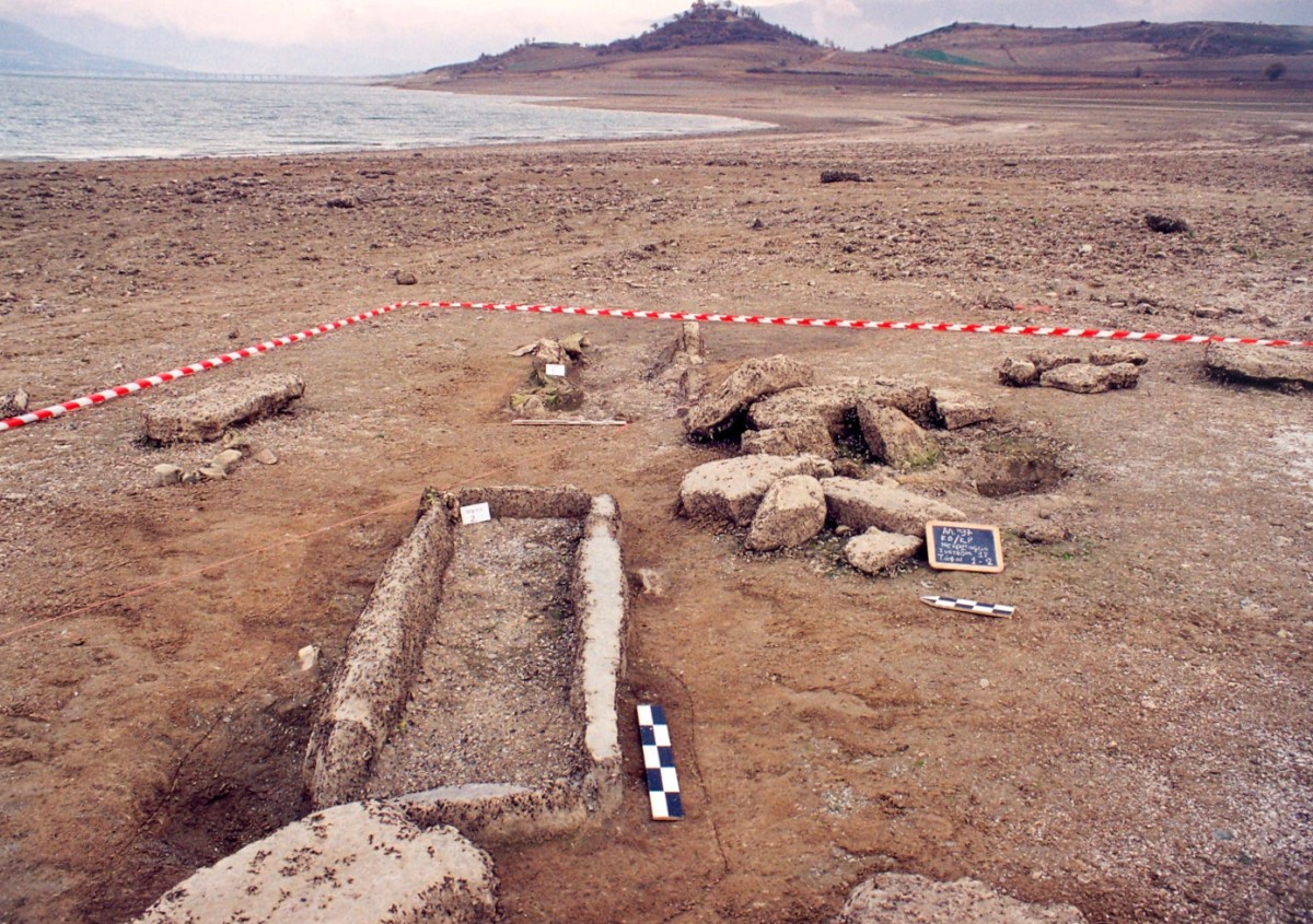 Fig. 3. Kriovrisi Kranidia, view of the eroded Late Bronze Age cemetery, within the Neolithic settlement. In the foreground a cist grave built with anthropomorphic stelae.