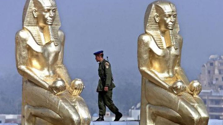 An Egyptian soldier walks between replica of pharonic statues placed at the site of Egypt's new Museum. Photo Credit: Marwan Naamani / AFP.