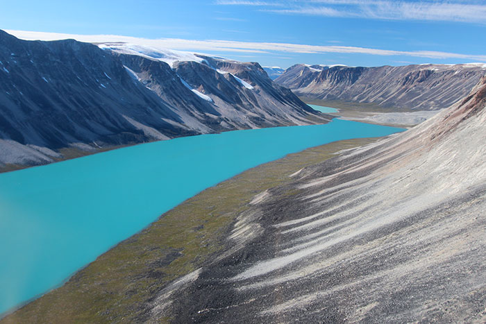 In western Greenland, small outlet glaciers are wasting backward, leaving behind piles of rocks, or moraines, that mark their previous advances. Meltwater has formed a lake. Photo Credit: Jason Briner.