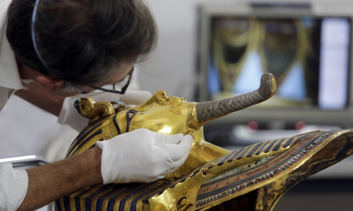 German conservator Christian Eckmann works on the restoration of the mask. (Photo credit: Amr Nabil/AP)