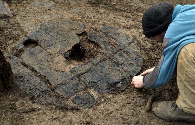 Excavation of Bronze Age Wheel at Must Farm one metre in diameter, with hub clearly visible. Credit: Cambridge Archaeological Unit, photo by Dave Webb