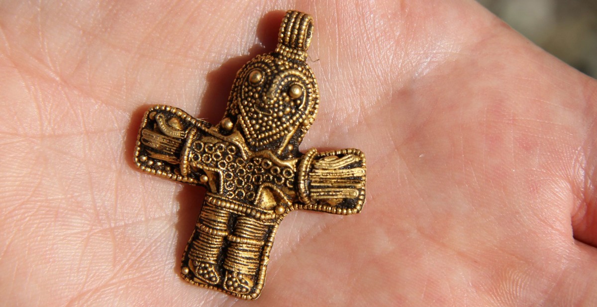 The small gold pendant, 4,1 cm in height, is in the shape of a man with outstretched arms – the image of Christ. 