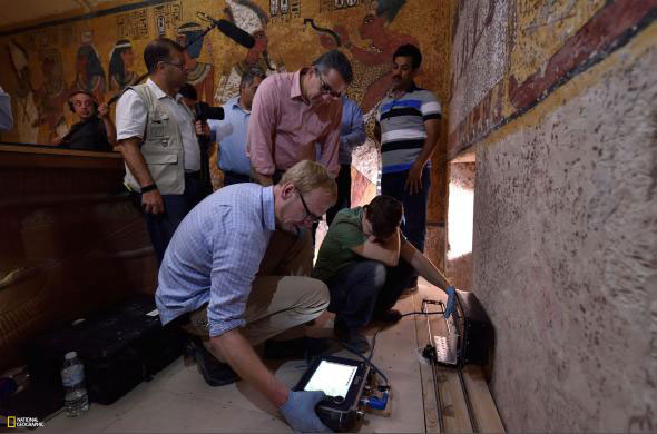 Facing the burial chamber’s east wall, Egypt’s Minister of Antiquities Khaled El-Enany (standing, in the pink shirt) observes the radar scanning in progress. Photo Credit: Keneth Garrett/NATIONAL GEOGRAPHIC.