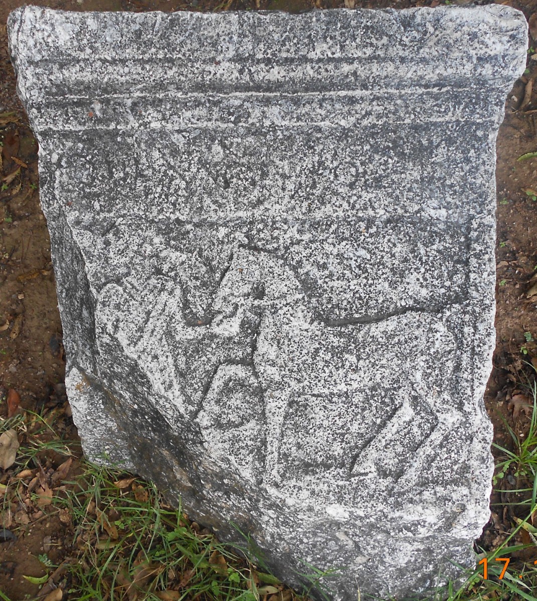 Fig. 4. Marble post with bas relief depiction of a restless colt being led by an adorned woman, with an illegible inscription (in the courtyard of a house in the Haliartos Gardens).