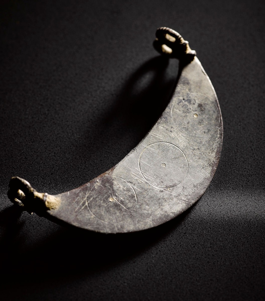 A crescent-shaped pendant that has two double loops. Photo Credit: Live Science.