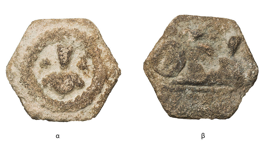 Fig. 1. Hexagonal shaped token. 26 millimeters Side a: Frontal bust of priest. Side b: Two human figures. Possibly a banquet scene. On the left, the impression of a private stamp can be distinguished. An inscription is on the exergue (Numismatic Museum 214/2005). Epigraphic and Numismatic Museum, Athens. ©The copyright belongs to the Ministry of Culture and Sports.
