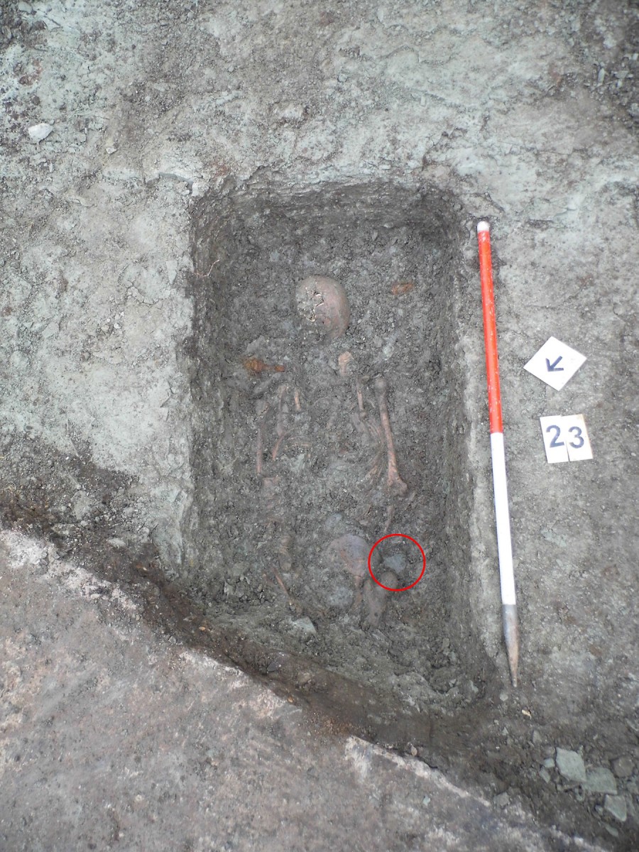 Fig. 2. The grave of Skeleton 23, thought to be a late Roman soldier or civil servant. The belt buckle was found next to the right hip (circled). 