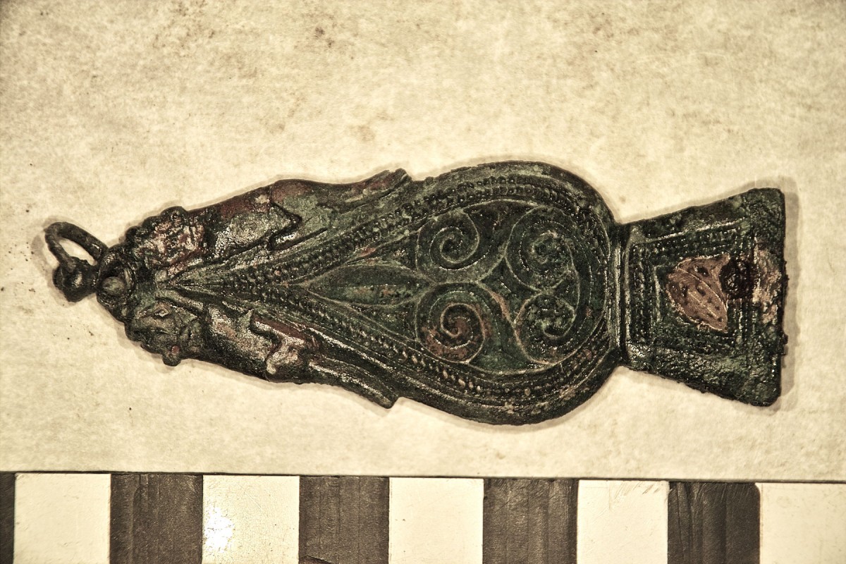 Fig. 6. The strap end is decorated with crouching dogs on either side of its tapered end. 