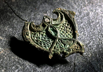 When a female Norwegian Viking died some time during the 9th century, she was buried wearing a status symbol: a beautiful piece of bronze jewellery worn on her traditional Norse dress.