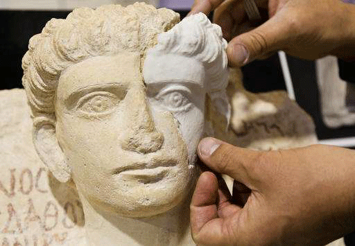 Restorer Antonio Laccarino Idelson shows a computer-rendered, 3D print-generated replica of a missing part of a limestone male bust. Photo Credit: AP/Domenico Stinellis/PhysOrg.