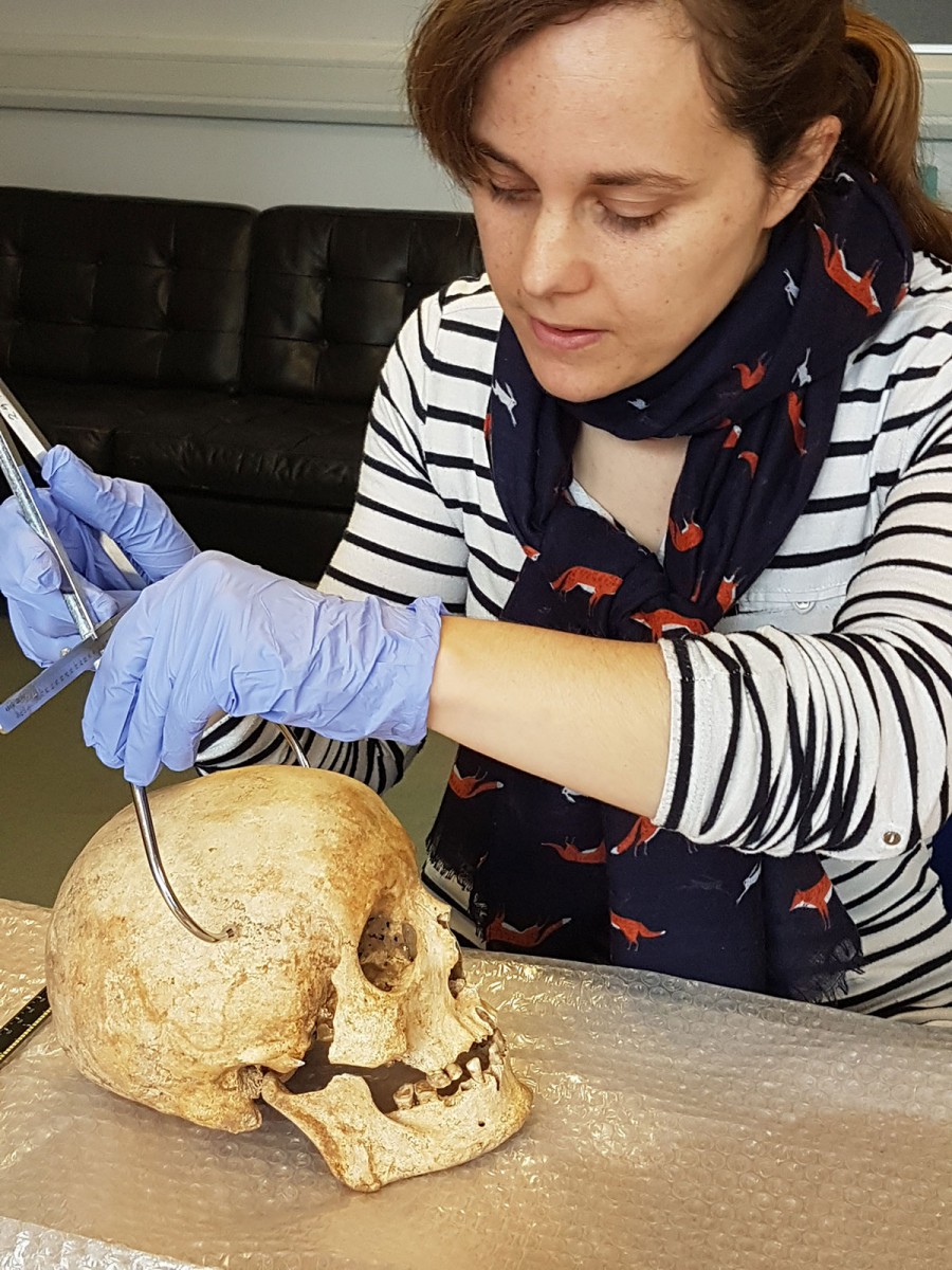 Dr Sarah Inskip examines the skull of Context 958. Image credit: Laure Bonner