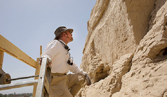 Yale Egyptologist John Darnell examines the hieroglyphs from atop a tall scaffold. Credit: Yale University. 