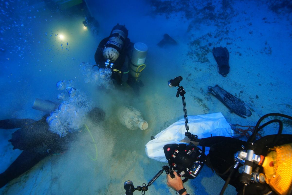 Archaeologists and the ROV robot clear sediment from a Roman North African amphora. Photo by Vasilis Mentogianis. Credit: Ephorate of Underwater Antiquities-Hellenic Ministry of Culture and Sports / RPM Nautical Foundation