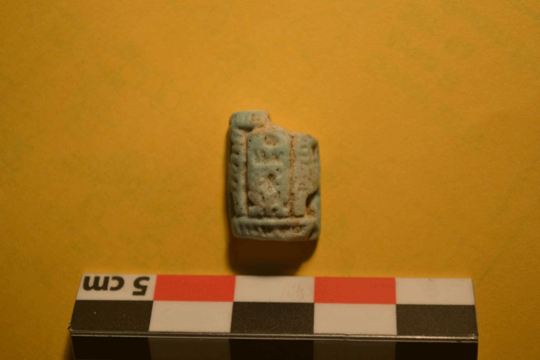 An amulet with a bifacial rectangular plaque with a barrel-shaped top. It contains Thutmose III cartouche flanked by a truth feather on each side and the base contains the name of Rameses II. Photo Credit: Tandy Institute for Archaeology/Haaretz.