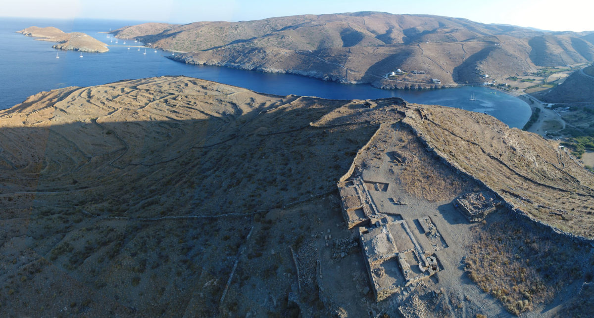 Fig. 16. Aerial photograph of the Ano Polis and buildings 1 and 2 on the Middle Plateau, from the south. In the background the sanctuary of Apollo and Artemis. Photo Credit: Kostas Xenikakis. 