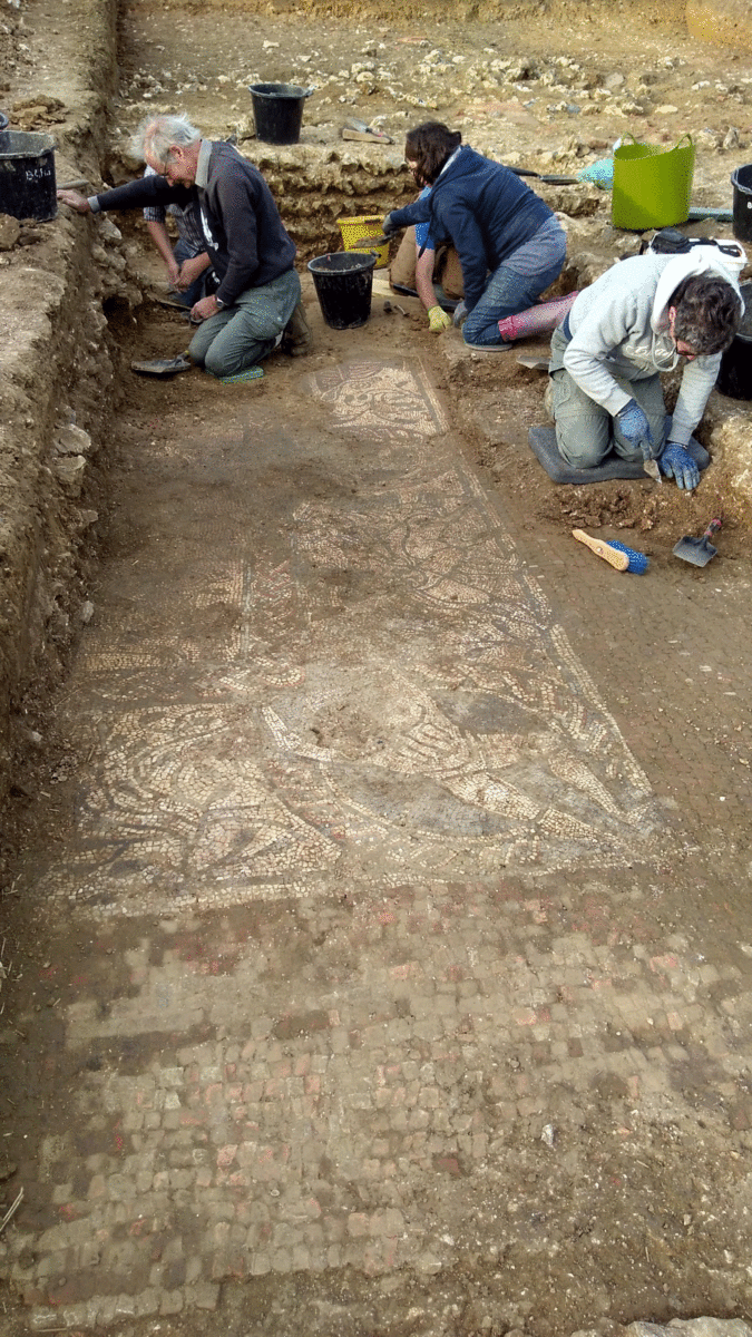 Archaeologists with the help of community volunteers excavate the mosaic. Photo Credit: Cotswold Archaeology/The History Blog. 