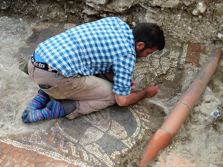 Matt Nichol working on the mosaic. Photo Credit: Cotswold Archaeology.