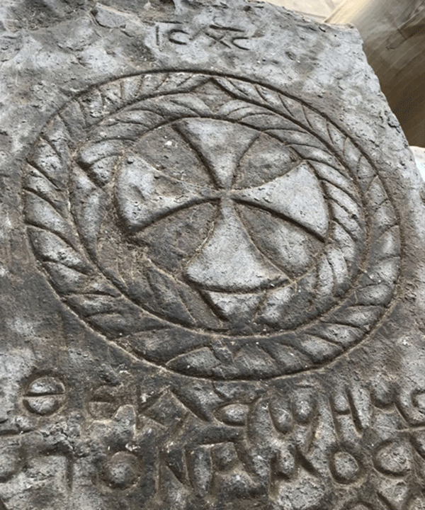The tombstone bears an engraved cross and Coptic texts inscribed on its surface. Photo Credit: Ahram Online.