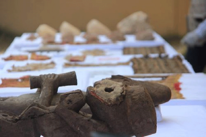 Four wooden sculptures, metal vessels, winkle shells and textiles were found at the site. Photo Credit: Andina.