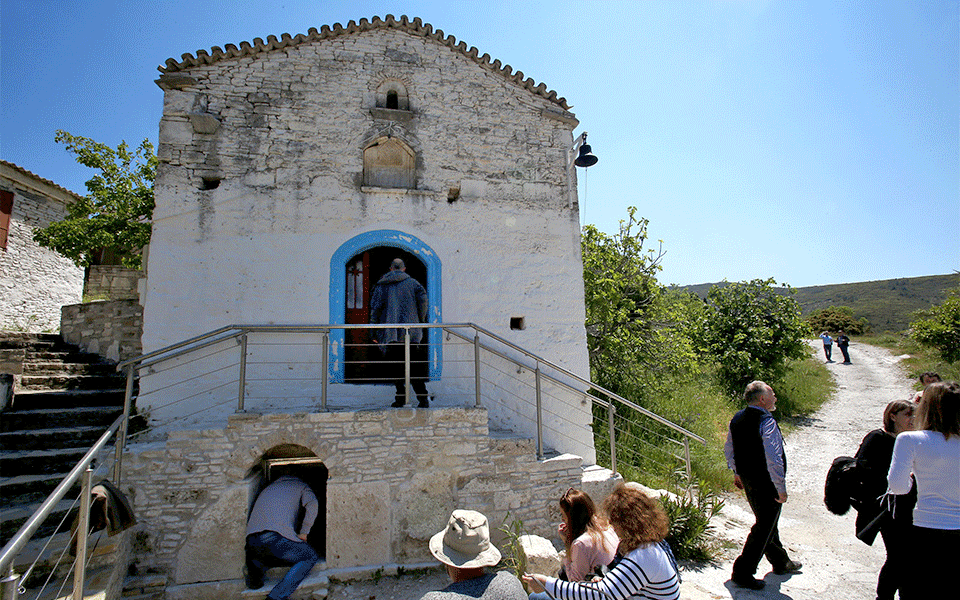 Tourists look at the ancient water tank at the exit of the tunnel of the Eupalinian Aqueduct. Photo Credit: © EPA/Simela Pantzartzi/TANN.
