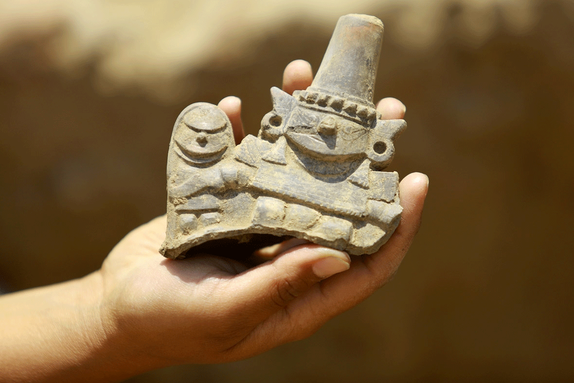 A worker shows a pottery artefact found at an archaeological site at Huaca de la Cruz in the Pomac Forest Historic Sanctuary, in Lambayeque, Peru. Photo Credit: Pierre Cobos/Reuters/IB Times.