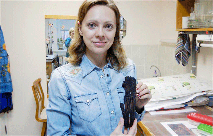 Dr Natalia Basova holds a figurine with a feather headdress. Photo Credit: Institute of Archaeology and Ethnography SB RAS/The Siberian Times.