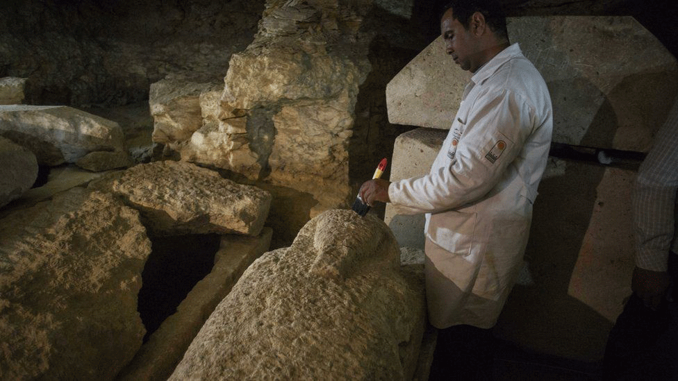 A worker is cleaning a sarcophagus found at the site. Photo Credit: EPA/BBC.