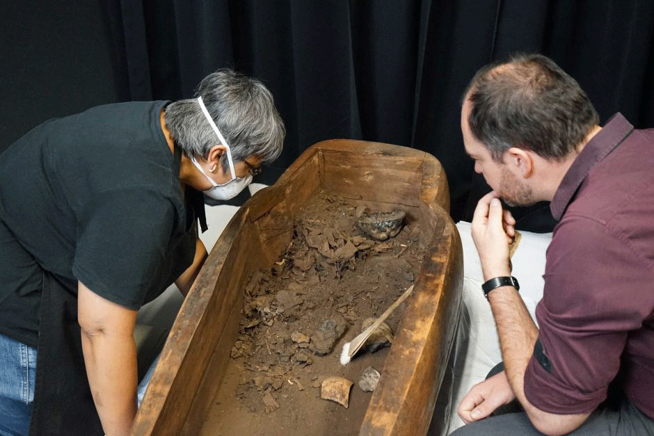 Scientists inspect the black lump of resin that was once inside the mummy's head. Photo Credit: ABC News/Natalia Morawski.