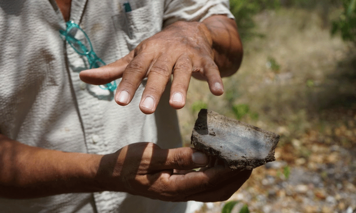 Researchers show some of the items excavated. Photo Credit: Gemma Handy/The Guardian.