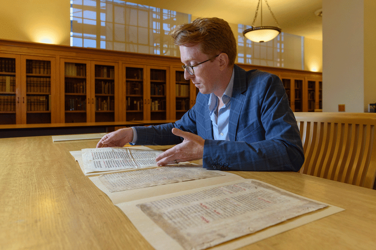 Rowan W. Dorin, assistant professor of history, with the miscataloged parchments whose mystery he is working to solve. Image Credit: L.A. Cicero / Stanford University.