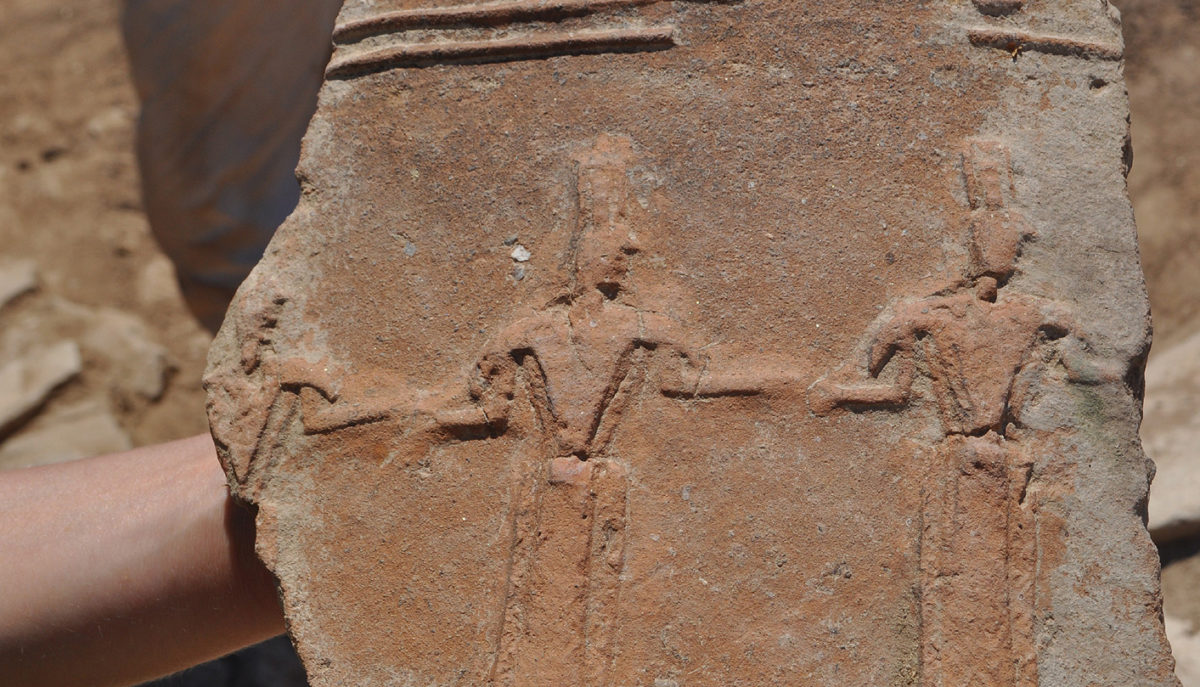 Two storage jars (pithoi) with relief decoration were found, one depicting a warrior and the other a dance performance.