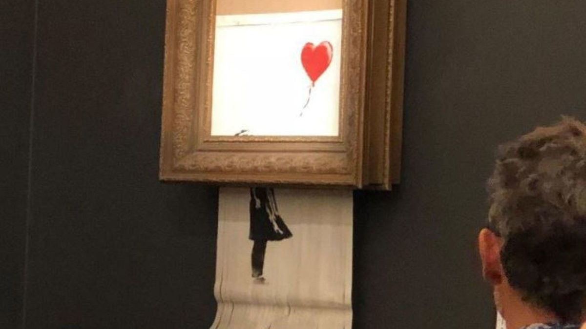 The “Girl with Balloon” was in fact torn into strips by a paper shredder attached by the artist to the back of the frame, but these pieces of the painting are now considered as a new work that Banksy himself has named “Love is in the Bin.”
