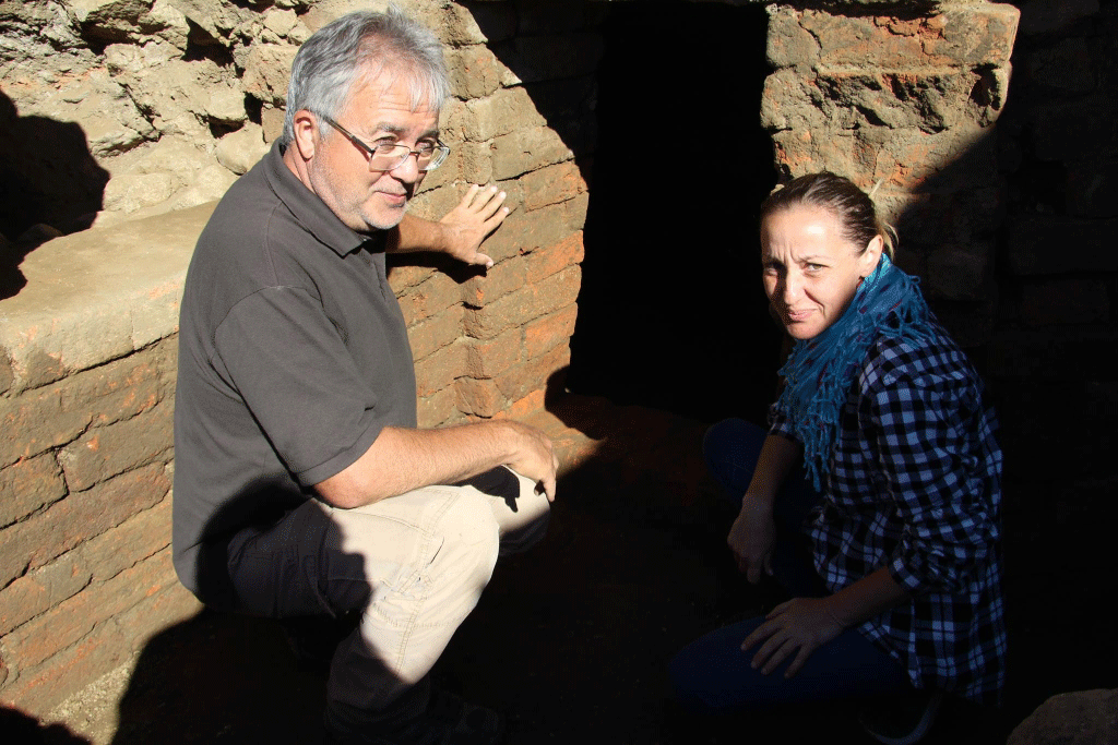 Archaeologists Georgi Nehrizov (left) and Meglena Parving (right) show the newly excavated Ancient Thracian tomb from the 3rd century BC. Photo Credit: Kazanlak Museum of History / Archaeology in Bulgaria.