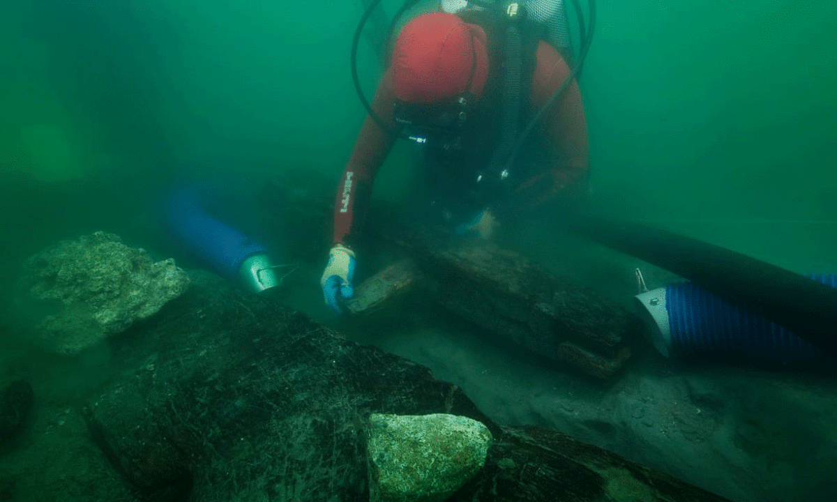 An archaeologist inspects the keel of a shipwreck discovered in the waters around the sunken port-city of Thonis-Heracleion. Photo Credit: Christoph Gerigk/Franck Goddio/Hilti Foundation/The Guardian.