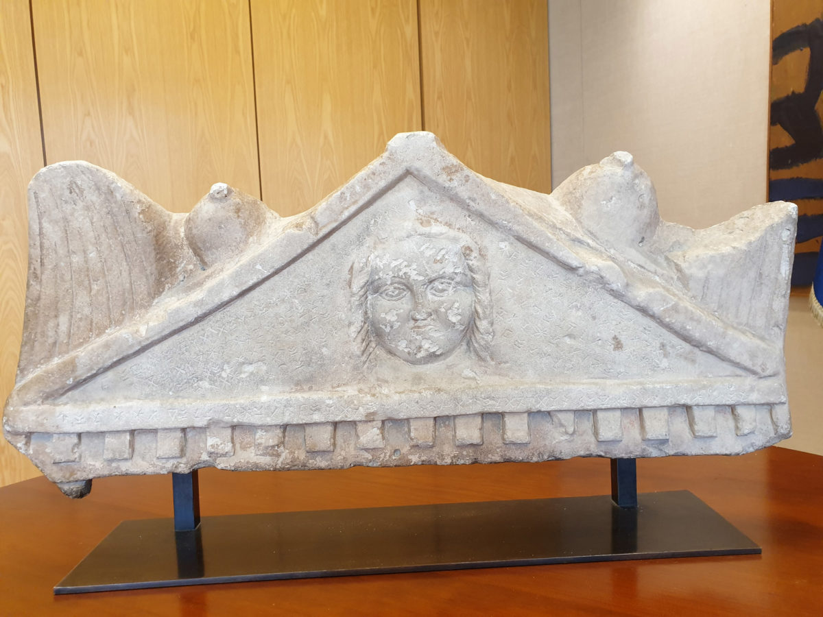 In the middle of the pediment, within the frame in relief, appears to be an apotropaic Medusa head (Gorgoneion). Photo credit: Department of Antiquities of Cyprus 
