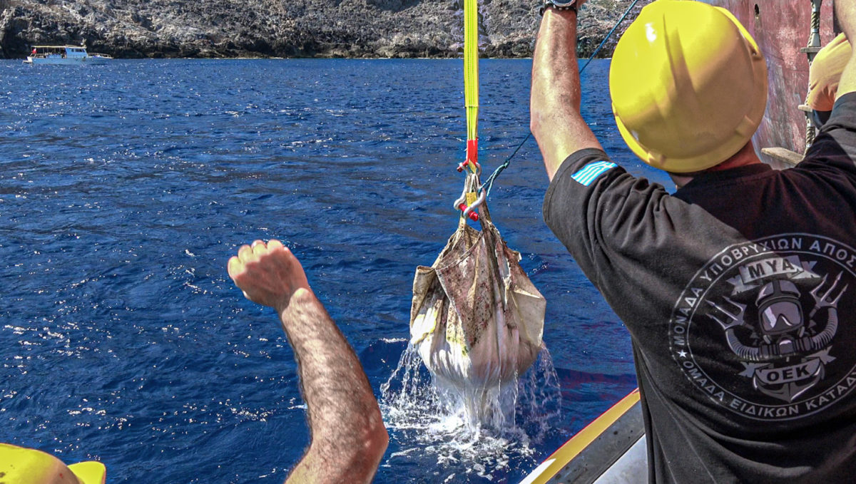 Man from the Underwater Missions Unit of the Greek Coast Guard participates in the final stage of recovering a sack of sand from the excavation of the Antikythera shipwreck (photo: MOCAS).