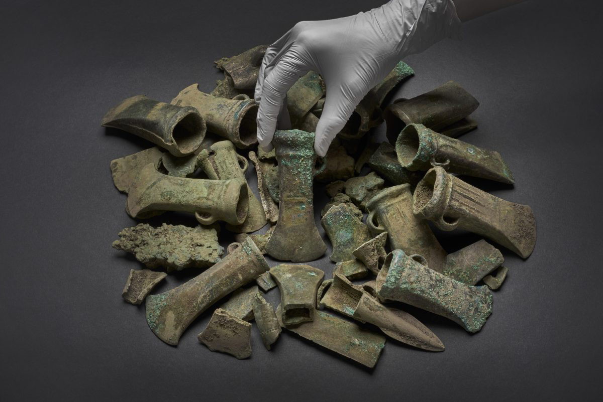 A Bronze Age axe head surrounded by a selection of objects from the Havering Hoard (c) Museum of London.