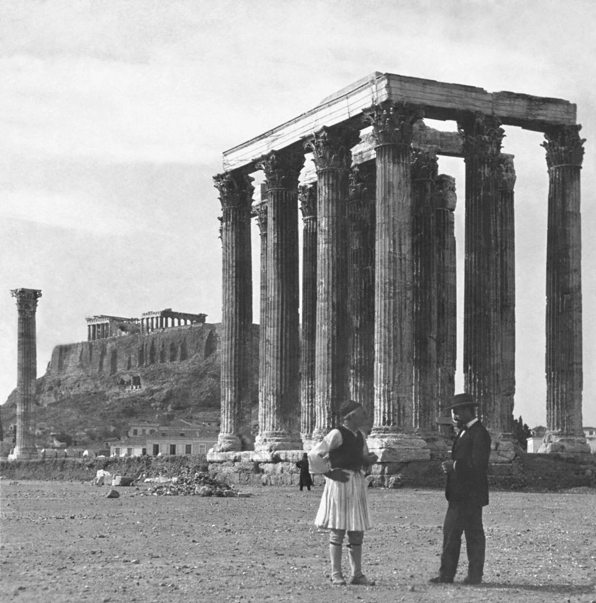 A guard in traditional Greek dress and a middle-class Athenian dressed in the manner talk in front of the temple of Olympian Zeus. Late 19th, early 20th century. Photographer unknown. Courtesy of the Library of Congress