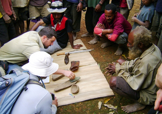 Dr Ben Shaw and some New Guinean locals examine a few of the artefacts unearthed at the Waim dig site in the northern highlands. Picture: UNSW/Ben Shaw